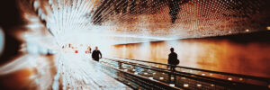 Two people riding a moving sidewalk into a bright white void to represent transformation