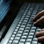 hands on a keyboard as if hacking into something