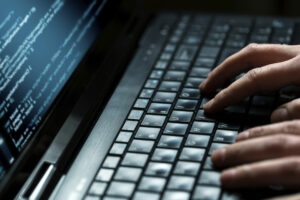 hands on a keyboard as if hacking into something