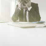 theft of trade secrets: A business man with his head in his hands dispairingnover the loss of his trade secrets. Theft of trade secrets is big problem for businesses.
