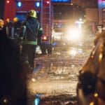 Emergency Response Plans - Firemen near their truck on the street having rest after they put out a fire at night. Emergency , danger, service concept. Firemen at work.