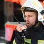 Crisis communication in action standing near a firetruck. Emergency safety. Protection, rescue from danger.